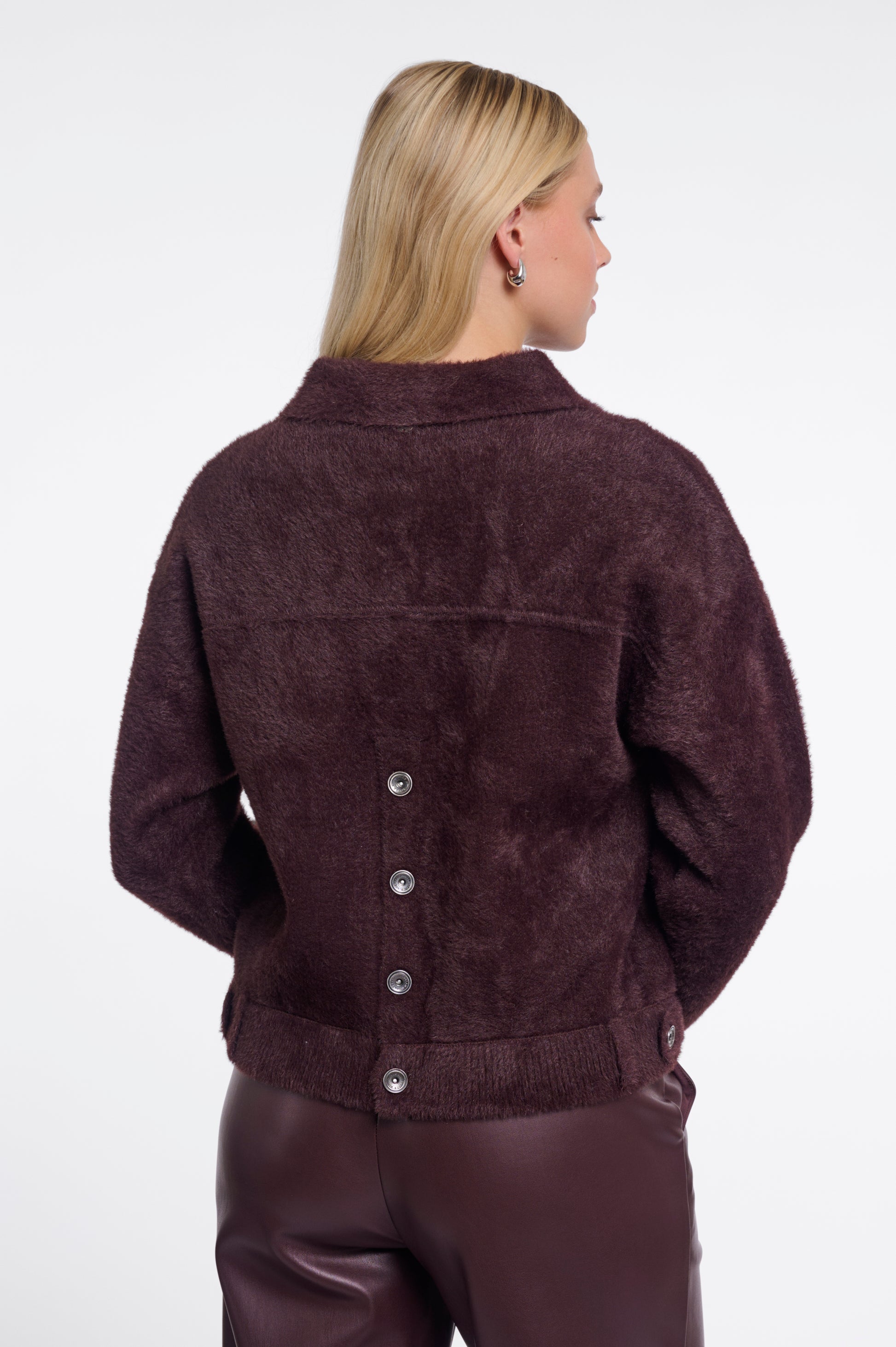 Woman wearing a brown suede jacket on a white background